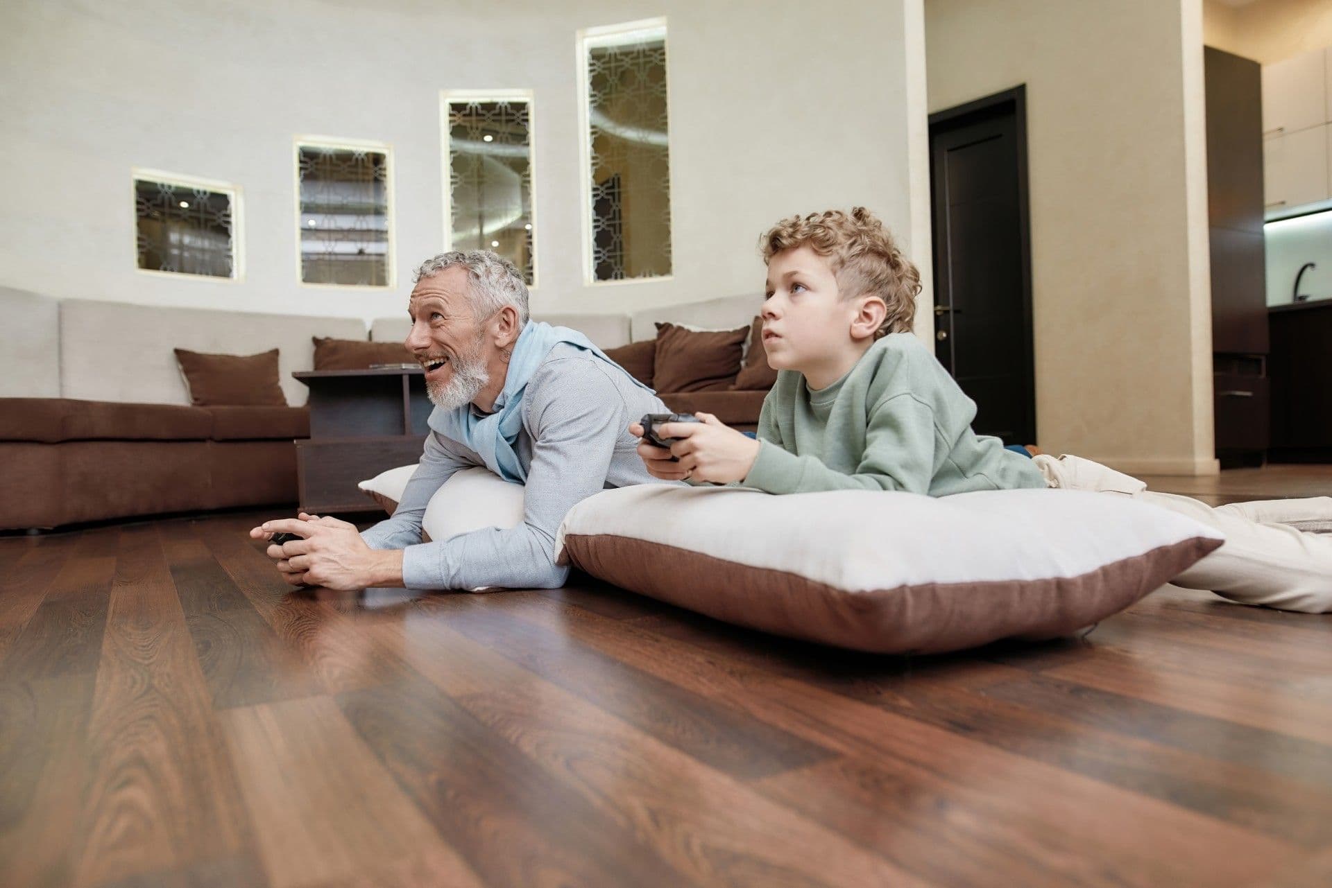 Dad and son playing video game on floor